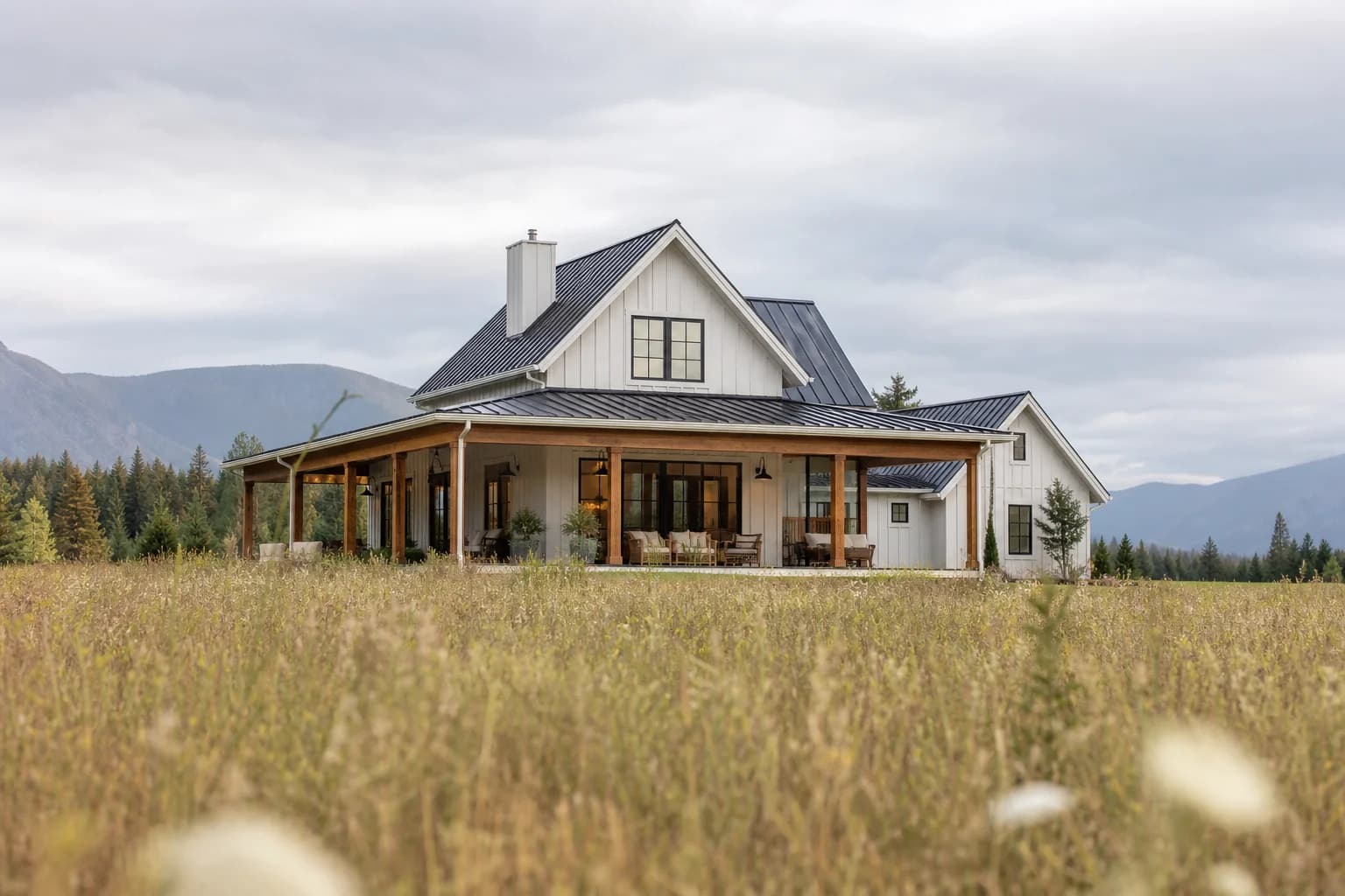 Modern BC farmhouse with wraparound porch and mountain backdrop
