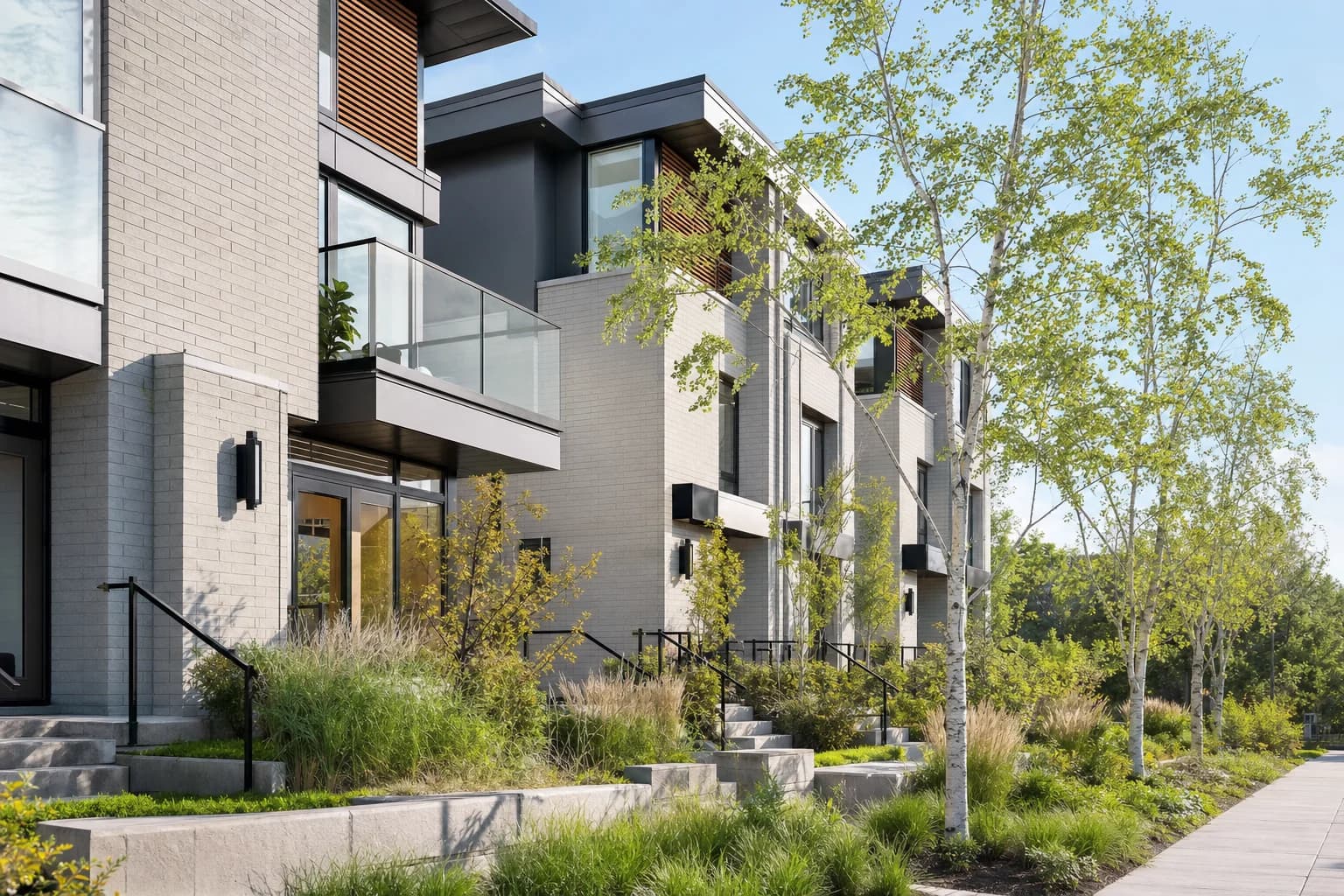 Modern Canadian townhouse complex with glass balconies and spring landscaping